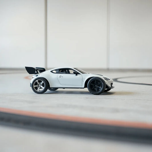 Remote control drift RC car angled mid-slide with visible tire grip on a clean track